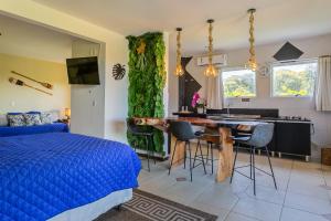 a bedroom with a bed and a table and a kitchen at Penareia Floripa Beach Hotel in Florianópolis