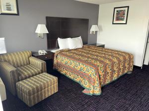 una habitación de hotel con una cama y una silla en Broadway Inn Motel, en San Antonio