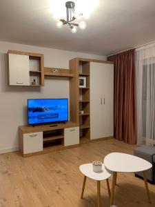 a living room with a television and a table at Sunny Apartment in Suceava in Suceava