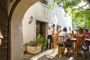 un grupo de personas sentadas en una mesa fuera de un restaurante en Majerija, en Vipava