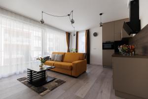 a living room with a couch and a table at Villa Bauhaus Wellness Apartman in Siófok