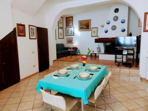 uma sala de jantar com uma mesa azul e um piano em casa panoramica em Teulada