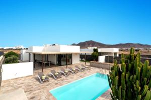 Blick auf ein Haus mit Pool und Kaktus in der Unterkunft Villa Salvia by Villa Plus in Playa Blanca