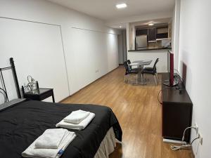 een slaapkamer met een bed en een tafel en stoelen bij Monoambiente en Caballito in Buenos Aires