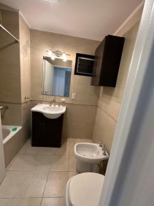W łazience znajduje się umywalka, toaleta i lustro. w obiekcie Monoambiente en Caballito w BuenosAires