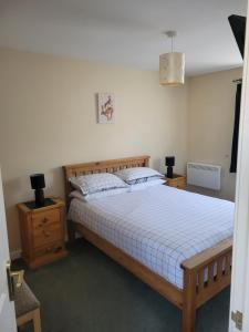 una camera con letto con struttura in legno e comodino di Arisaig Flat a Inverness