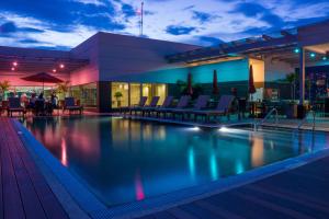 una piscina por la noche con sillas y un edificio en Hyatt Place Tegucigalpa en Tegucigalpa