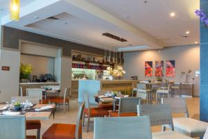 un ristorante con tavoli e sedie e un bar di Hyatt Place Tegucigalpa a Tegucigalpa