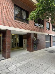 a brick building with a sidewalk in front of it at Monoambiente en Caballito in Buenos Aires