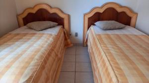 two beds sitting next to each other in a room at APT. 2/4 - Prive das Thermas I - 7 piscinas termal - Apclube Tur in Caldas Novas
