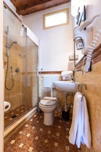 ein Bad mit einem WC, einer Dusche und einem Waschbecken in der Unterkunft Duomo Apartments Cefalù in Cefalú
