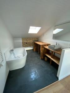 a bathroom with a bath tub and a sink at Chez James in Gujan-Mestras