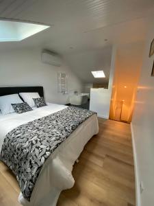 een slaapkamer met een groot bed en een badkamer bij Chez James in Gujan-Mestras