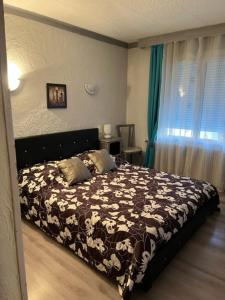 ein Schlafzimmer mit einem Bett mit einer schwarzen und weißen Decke in der Unterkunft Attrap'Rêves in Aspres-sur-Buëch