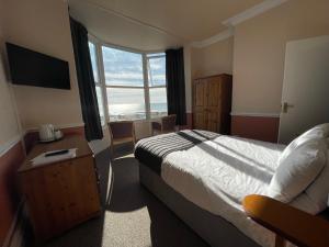 a hotel room with a bed and a large window at The Sandbanks in Barmouth
