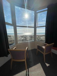 2 sillas en una habitación con ventana grande en The Sandbanks en Barmouth