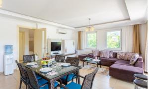 a living room with a purple couch and a table at Villa Günsu in Ortaca