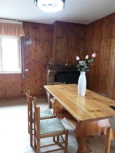 una mesa de madera con un jarrón de flores. en La Cascina di Fox, en Terni