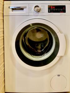 una lavatrice bianca con porta aperta di Hostel Best Stay a Madrid