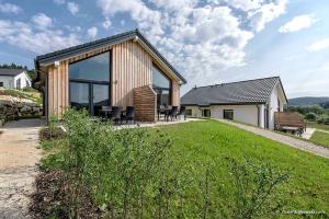 une maison avec des portes en verre et une cour herbeuse dans l'établissement Panoramabungalow _50_ im Feriendor, à Truppach