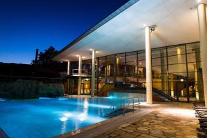 un gran edificio con piscina por la noche en Panoramabungalow _50_ im Feriendor en Truppach