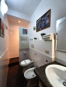 y baño con aseo blanco y lavamanos. en 50 Passi Colosseo Apartment, en Roma
