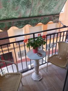 a table with flowers on a balcony with chairs at Sweet dreams in Alicante