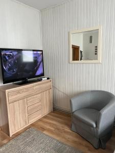 a living room with a television and a chair at Apartament Relax in Stronie Śląskie