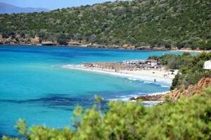 a beach with a group of people in the water at casa panoramica in Teulada