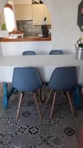 a table with two blue chairs in a kitchen at Bungalow in Moorse stijl in El Campello