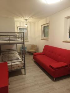 ein Wohnzimmer mit einem roten Sofa und einem Etagenbett in der Unterkunft Wohnung in der zentrale Lage bis zu 5 Personen in Leipzig