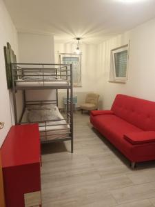 ein Wohnzimmer mit einem Etagenbett und einem roten Sofa in der Unterkunft Wohnung in der zentrale Lage bis zu 5 Personen in Leipzig