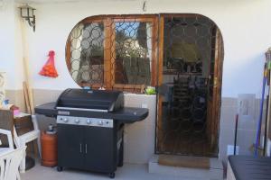 a kitchen with a grill and a door with a window at Bungalow in Moorse stijl in El Campello