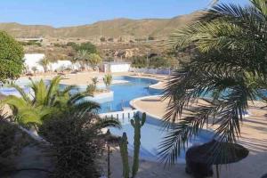 a resort with two pools and palm trees at Bungalow in Moorse stijl in El Campello