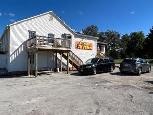 dois carros estacionados num parque de estacionamento em frente a um edifício em Pebbles Suite above Bedrock Tavern em Sandusky