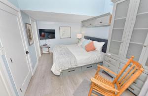 a small bedroom with a bed and a wooden chair at Harbourfront Executive Stay in Victoria