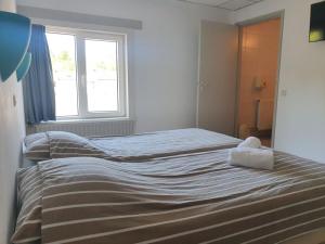 a bedroom with two beds and a window at Hotel Restaurant Sence in Burgh Haamstede