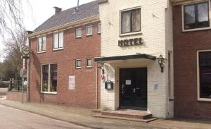 un bâtiment en briques avec une porte dans une rue dans l'établissement Hotel Restaurant Sence, à Burgh-Haamstede