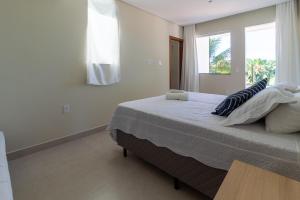 Un dormitorio con una cama grande con ventana. en Apartamento em Arraial, en Arraial d'Ajuda