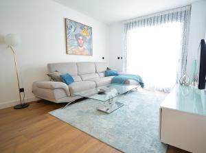 a living room with a couch and a glass table at Tu oasis con piscina en Portonovo Sanxenxo in Sanxenxo
