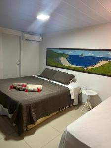 una camera da letto con un letto e un quadro sul muro di Pousada São Silmares a Fernando de Noronha