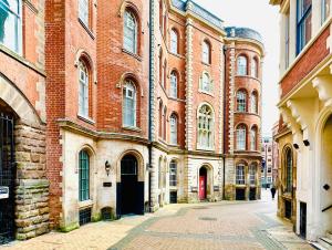 an empty street in front of a large brick building at Lovely Studio Apartment in the Heart of Nottingham in Nottingham