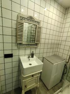 a white bathroom with a sink and a mirror at Apartament przy Zamku Krzyżackim in Malbork