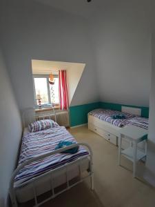 Duas camas num pequeno quarto com uma janela em Bramaublick em Hitzhusen