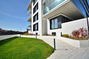 a large white building with a lawn in front of it at Tu oasis con piscina en Portonovo Sanxenxo in Sanxenxo