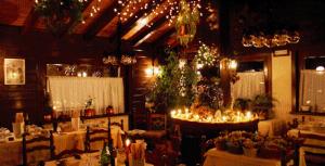 un comedor con mesas, sillas y luces en Hotel Tersiva en Valtournenche