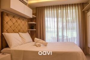 a bedroom with a bed with a large window at Qavi - Apto em Resort Beira Mar Cotovelo #InMare43 in Parnamirim +11 photos