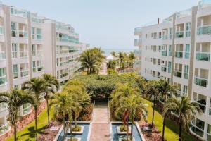 - une vue aérienne sur la cour d'un immeuble avec des palmiers dans l'établissement Qavi - Apto em Resort Beira Mar Cotovelo #InMare43, à Parnamirim