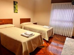 a room with two beds with towels on them at Hostal Merindades in Villarcayo