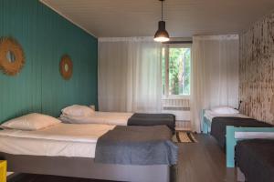two beds in a room with green walls and a window at Tuba järveäärses puhkemajas - Saarjärve Puhkemaja in Tromsi